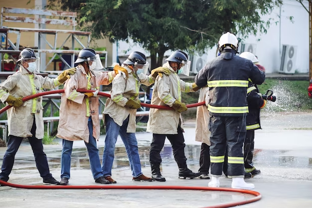 Line of people in firefighter vests with a water hose